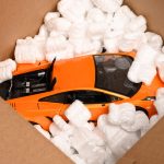 Loose fill in a cardboard box, protecting an orange model car