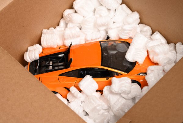 Loose fill in a cardboard box, protecting an orange model car