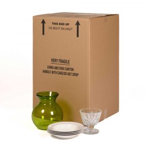China and dish carton with green vase, dishes and glassware placed in front of it