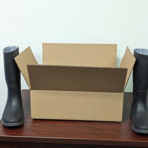 A pair of rain boots sit next to a 16x12x5 inch stock box