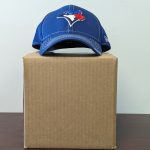 Baseball cap sits on top of a 8x8x8 inch stock box