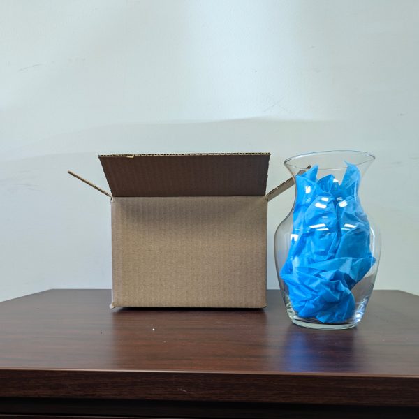 Vase with blue packing paper in it sits next to 9x6x6 inch stock box