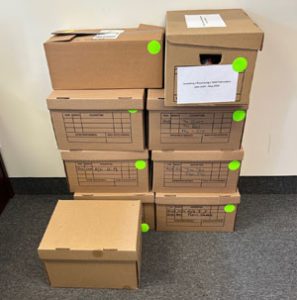 Stacked file boxes are labeled with bright green dots. One box also includes a sign indicating what kind of files are in the boxes.